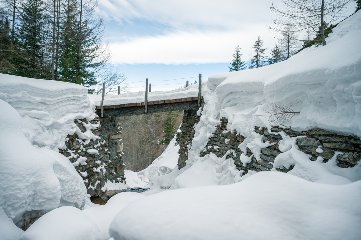 Der Waldabschnitt endet mit dem Überqueren dieser Brücke. Bild: Jon Guler  