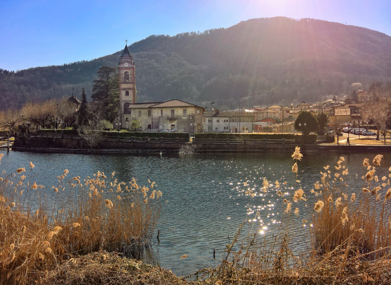 Qui l'Italia è a due passi: da Torrazza si vede, attraverso lo stretto braccio del Lago di Lugano, la chiesa di Lavena. Immagine: Andreas Staeger