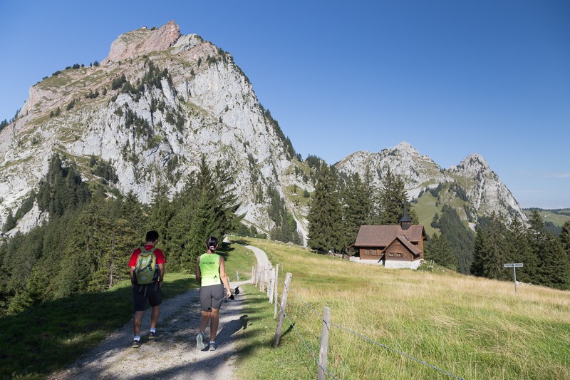 La cappella di montagna poco prima di Holzegg sembra minuscola accanto all’imponente Mythen. Qui l’itinerario si snoda lungo una strada alpestre e in seguito lungo un sentiero stretto. Foto: Markus Ruff